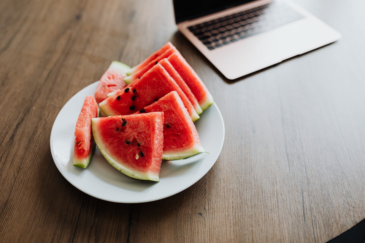 sliced watermelon and laptop